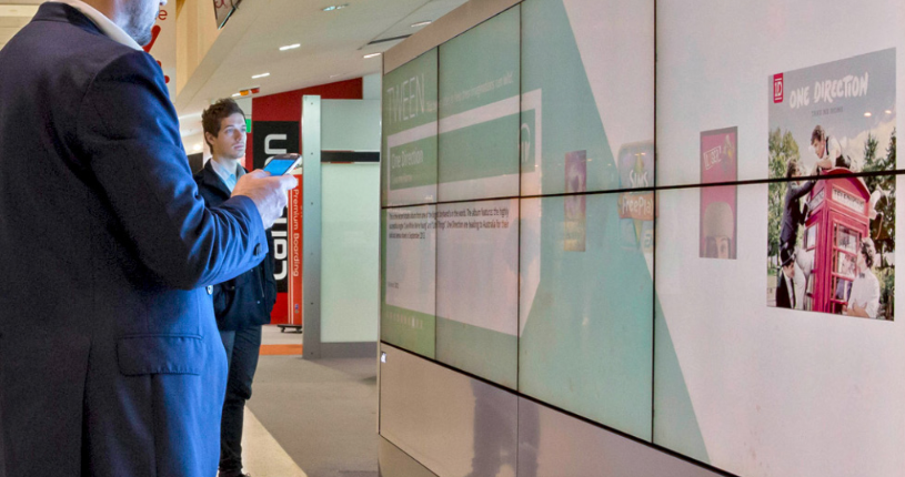 people looking at a video wall